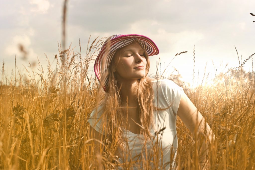 A blonde hair girl in a field.