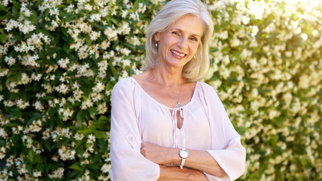 older woman smiling and standing outside in spring, diva
